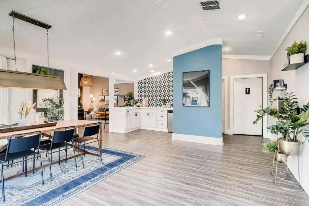 Clubhouse interior with kitchenette, table seating, and computer desks